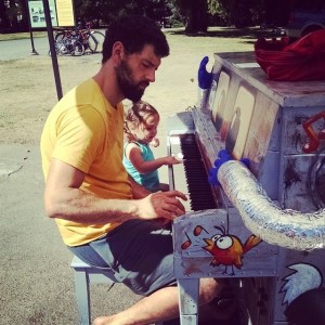 A father and daughter try out a public park piano in Seattle, WA